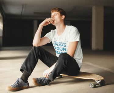 T-Shirt Mockup Featuring a Man Sitting on a Skateboard