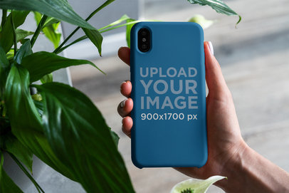Mockup of Someone Holding a Phone Case Next to a Plant 4619-el1