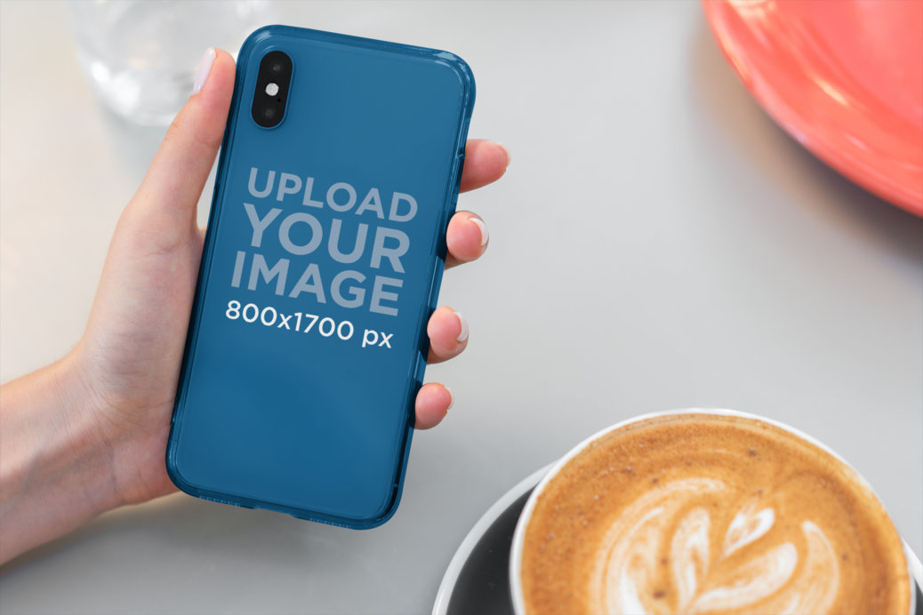 Mockup of Someone Holding a Clear Phone Case at a Cafe