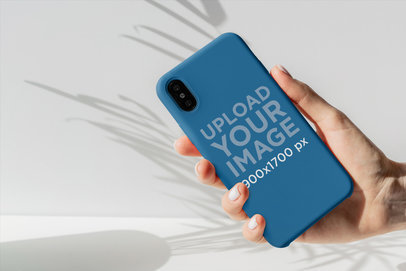 Mockup of Someone Holding a Phone Case Against a Plain Background