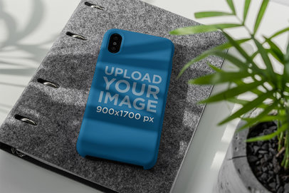 Mockup of a Phone Case Placed Under a Little Plant
