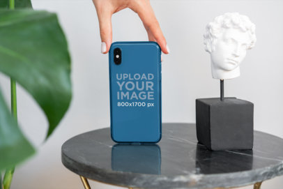 Mockup of a Woman Holding a Clear Phone Case Next to an Ornament 4642-el1