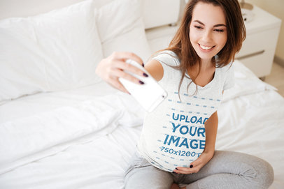 Mockup of a Pregnant Woman with a Heather Shirt Taking a Selfie 