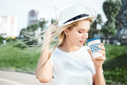 Mockup of a Young Woman Drinking Coffee from a Paper Cup