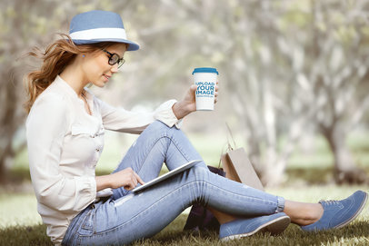 Mockup of a Woman Holding a Paper Cup While Reading From a Tablet 