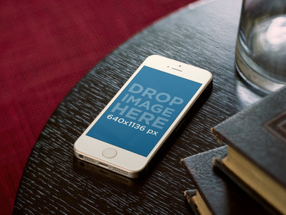 Mockup of a Gold iPhone 5s Placed over a Wooden Round Table