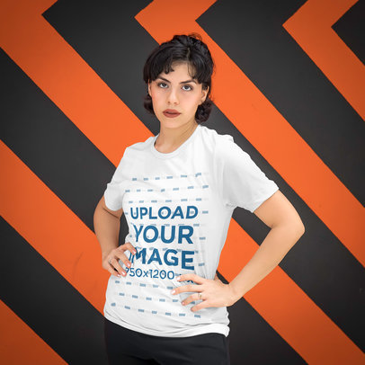 T-Shirt Mockup Featuring a Woman Standing in Front of a Patterned Wall 