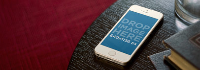 Mockup of an iPhone 5s Placed on a Dark Wooden Table