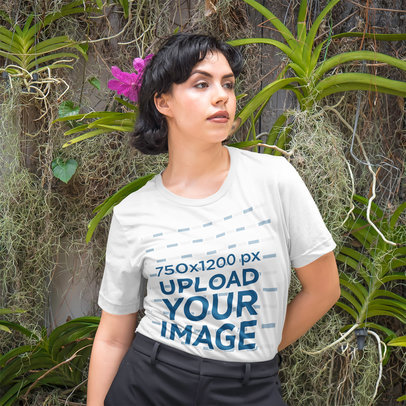 T-Shirt Mockup of a Fierce Woman Posing in Front of a Nature Wall