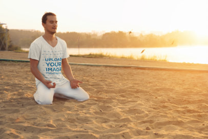 Mockup of a Man with a V-Neck Heathered Shirt Meditating on the Sand