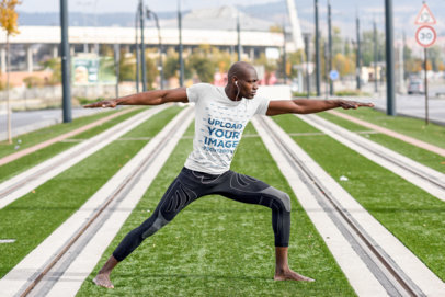 T-Shirt Mockup of a Man Doing Yoga on a Tramway Track