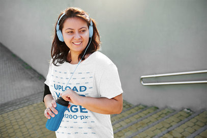Mockup of a Happy Woman Wearing a Heather T-Shirt and Listening to Music 