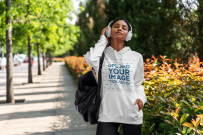 Pullover Hoodie Mockup of a Woman Listening to Music 