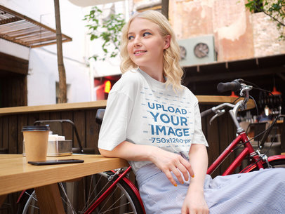 T-Shirt Mockup of a Woman at a Coffee Shop