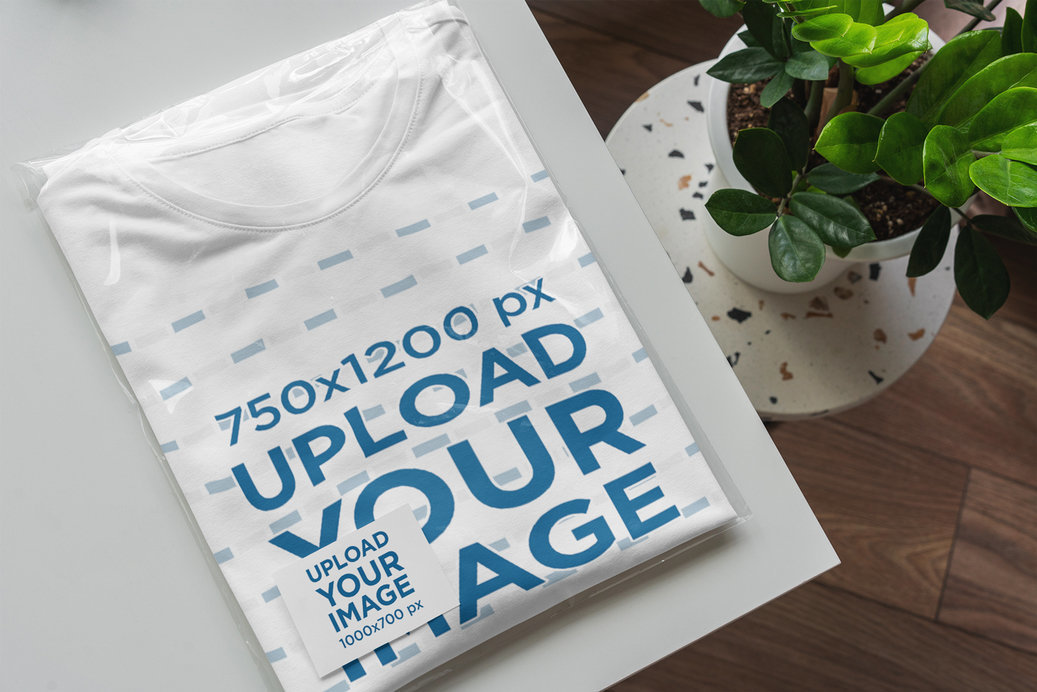 Mockup of a Folded T-Shirt Wrapped in a Transparent Bag with a Business Card Inside