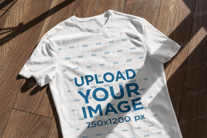 T-Shirt Mockup Featuring a Wooden Surface and a Window Shadow 
