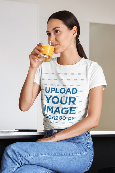 T-Shirt Mockup of a Woman Drinking Orange Juice at Home