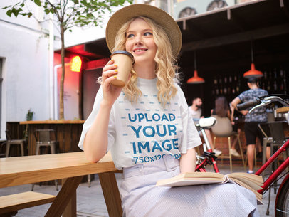 Mockup of a Woman Wearing a Unisex T-Shirt at a Coffee Shop 