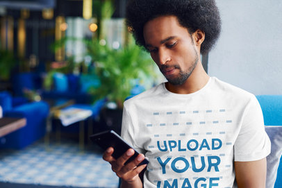 T-Shirt Mockup of a Man with a Beard Checking His Phone