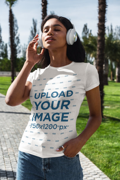 T-Shirt Mockup of a Young Woman Listening to Music at a Park 