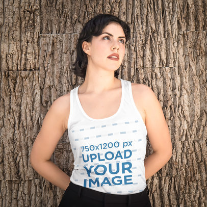 Tank Top Mockup of a Woman Leaning Against a Wall With a Tree Bark Texture
