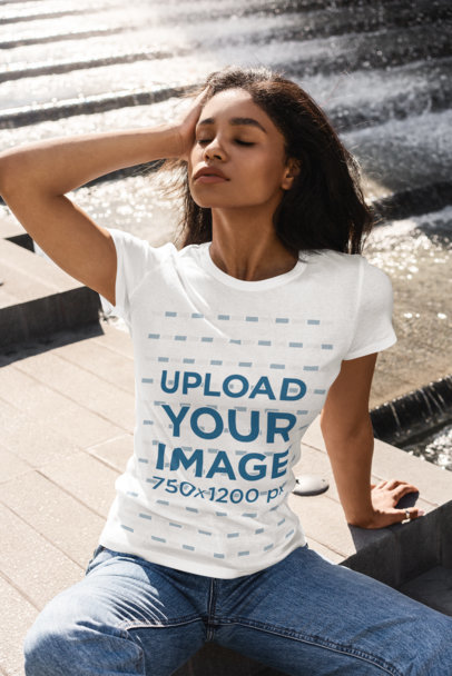 T-Shirt Mockup of a Woman Sitting on the Floor by a Fountain 