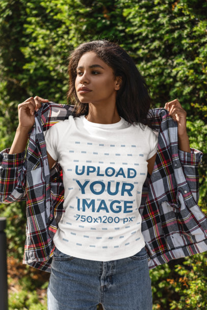 T-Shirt Mockup of a Young Woman Standing in Front of a Green Wall
