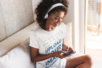 Tee Mockup of a Smiling Woman Listening to Music at Home 