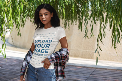 T-Shirt Mockup of a Young Woman Standing Under a Tree
