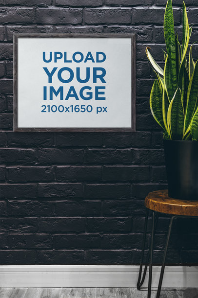 Mockup of a Framed Art Print Hanging by an Indoor Plant 