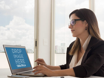 Mockup Featuring a Woman Using Laptop in an Office