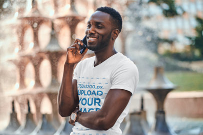 V-Neck T-Shirt Mockup of a Man Posing by a Fountain 