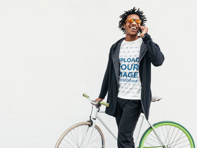 T-Shirt Mockup of a Man Talking on the Phone while Holding His Bike