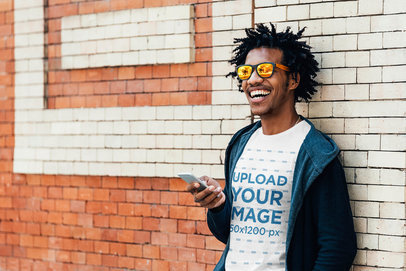 Mockup Featuring a Happy Man with a T-Shirt Holding a Phone