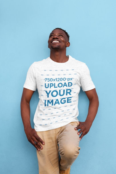 T-Shirt Mockup of a Man Leaning Against a Colored Wall 