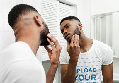 T-Shirt Mockup of a Man Checking His Beard in the Mirror