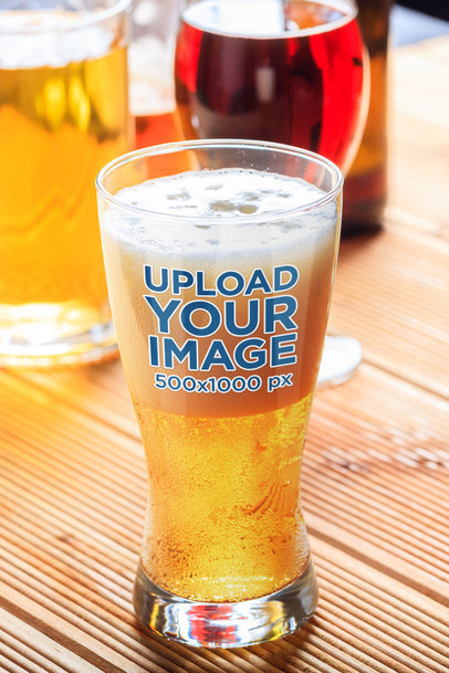 Mockup of a Tall Beer Glass Placed on a Wooden Table