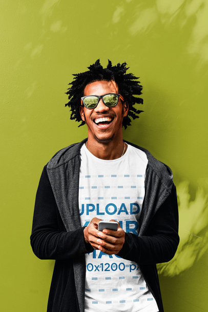 T-Shirt Mockup of a Man Laughing in Front of a Colored Wall