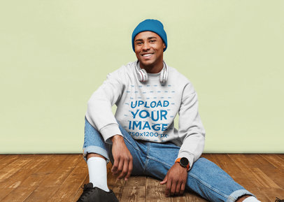 Crewneck Sweatshirt Mockup of a Happy Man Sitting on a Wooden Floor 