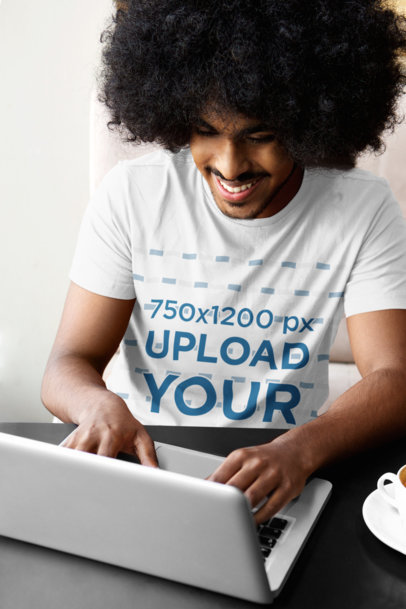 T-Shirt Mockup of a Happy Man Working on His Laptop