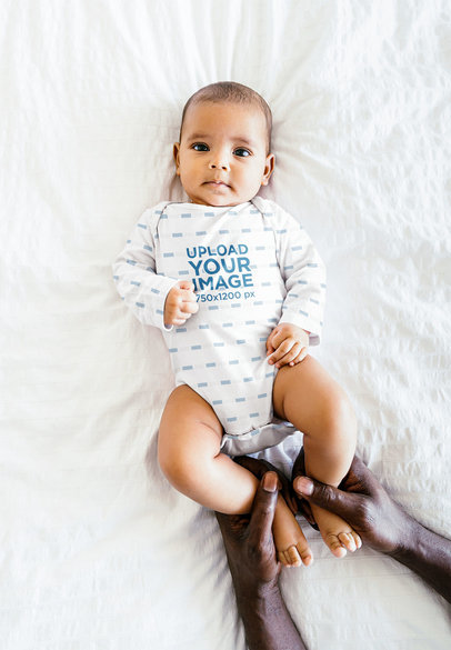 Mockup Featuring a Calmed Baby Wearing an Onesie
