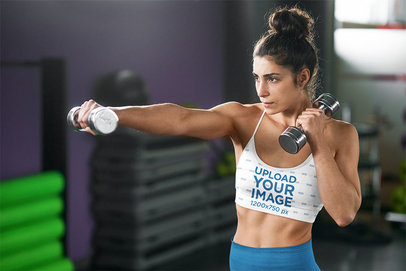 Sports Bra Mockup of a Serious Woman Training With a Pair of Dumbbells 