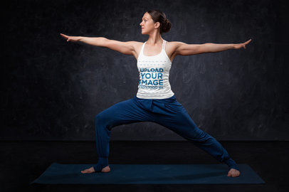 Tank Top Mockup of a Woman Practicing Yoga in Front of a Dark Wall 