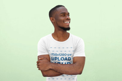 T-Shirt Mockup Featuring a Smiling Young Man in a Studio