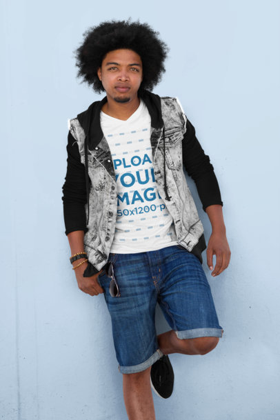 T-Shirt Mockup of a Bearded Man Leaning Against a Customizable Color Wall