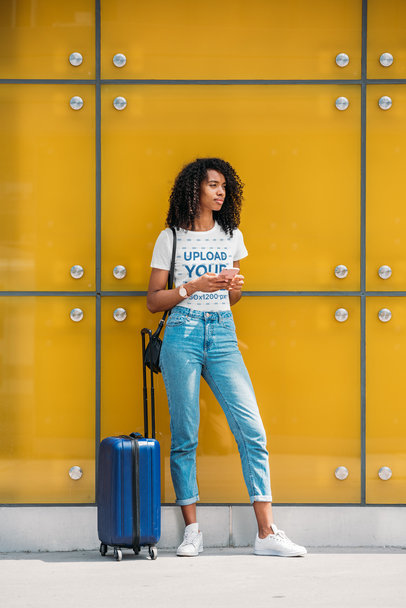 T-Shirt Mockup of a Woman with a Suitcase Waiting on the Street