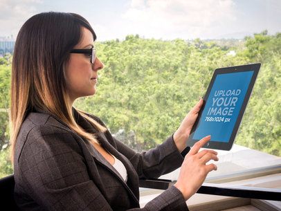 Mockup Featuring a Woman Using an iPad in Office -