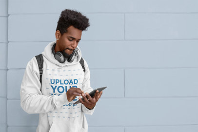 Hoodie Mockup of a Student Checking His Tablet 
