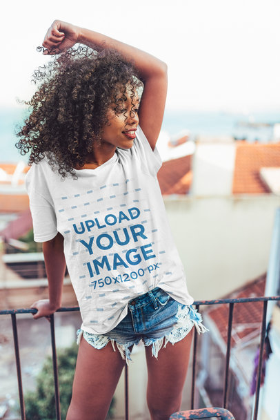Mockup of a Curly-Haired Woman Wearing an Oversized T-Shirt on a Balcony 34951-r-el2