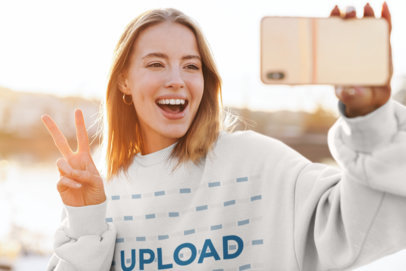 Selfie Mockup of a Happy Woman Wearing a Crewneck Sweatshirt Outside